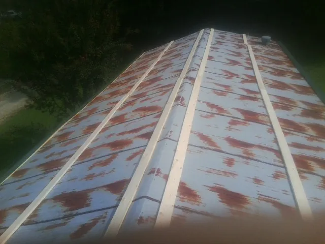Rusted metal roof panels with new wood purlins before replacement — Storm Damage Roof Repair in Whaleyville by Roofing Brothers