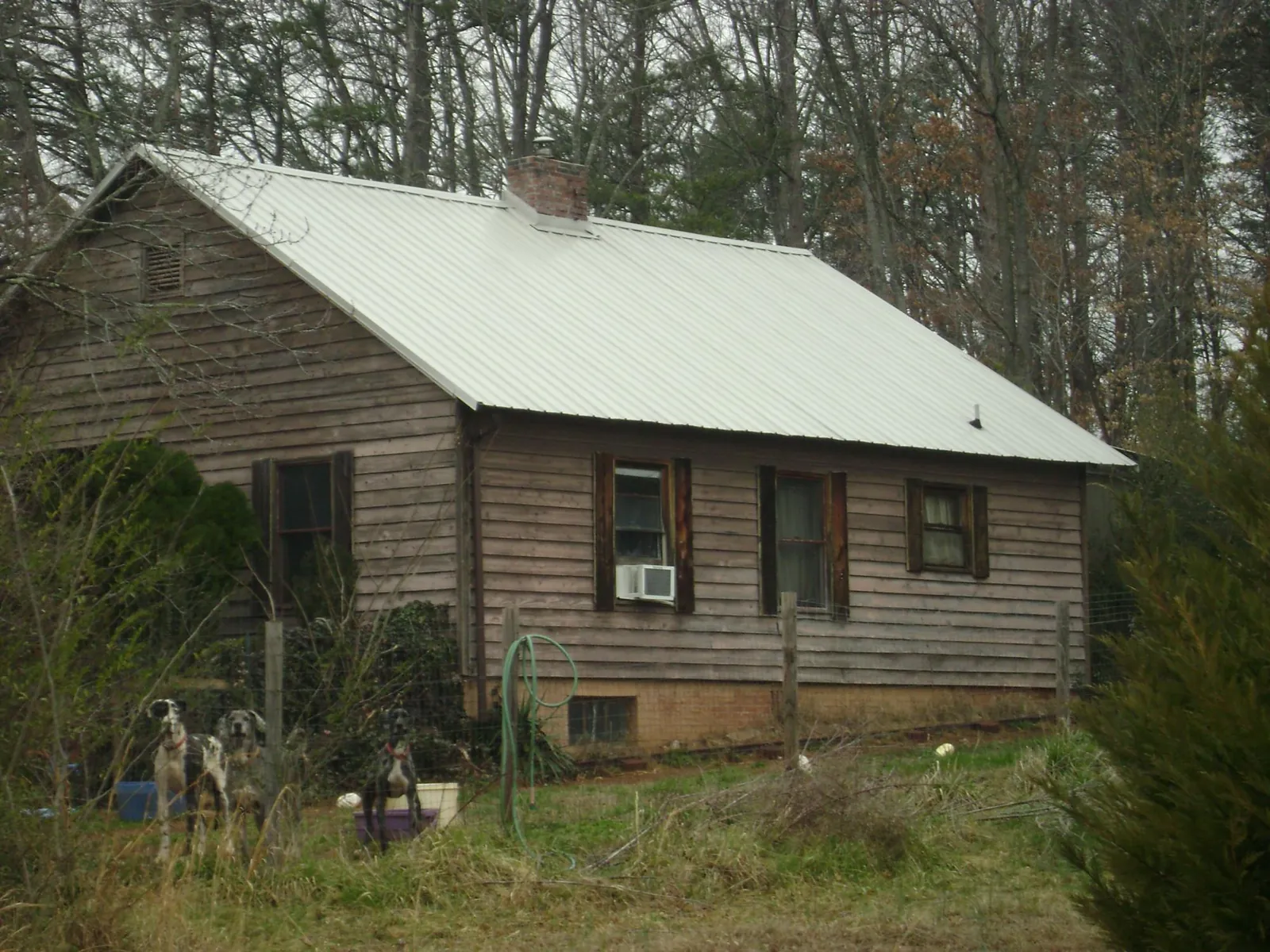 White metal roof on an old wood sided farmhouse, from a Metal Roof Installation job in Whaleyville